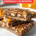 Barritas energéticas caseras de naranja y almendra sobre una tabla de madera.