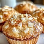 Panecillos caseros esponjosos con plátano, coco y almendras, servidos sobre una bandeja de madera.