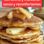 Panqueques caseros de queso cottage con avena y manzana servidos en un plato, acompañados de rodajas de manzana y miel.