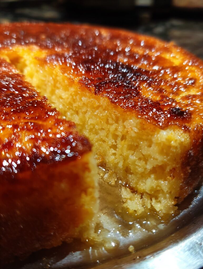 Pastel casero de elote y queso, dorado por fuera, con textura cremosa por dentro, servido en porciones sobre plato rústico.