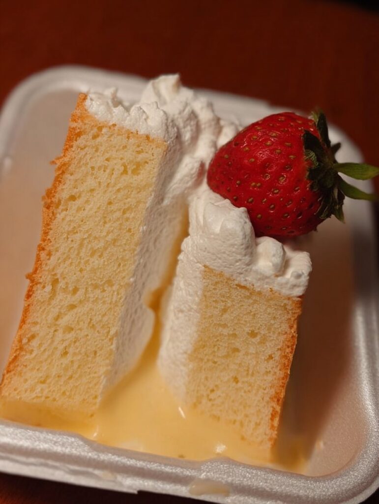 Pastel beso de ángel casero sobre una mesa rústica, con capas visibles de pan, flan y chantilly con cajeta