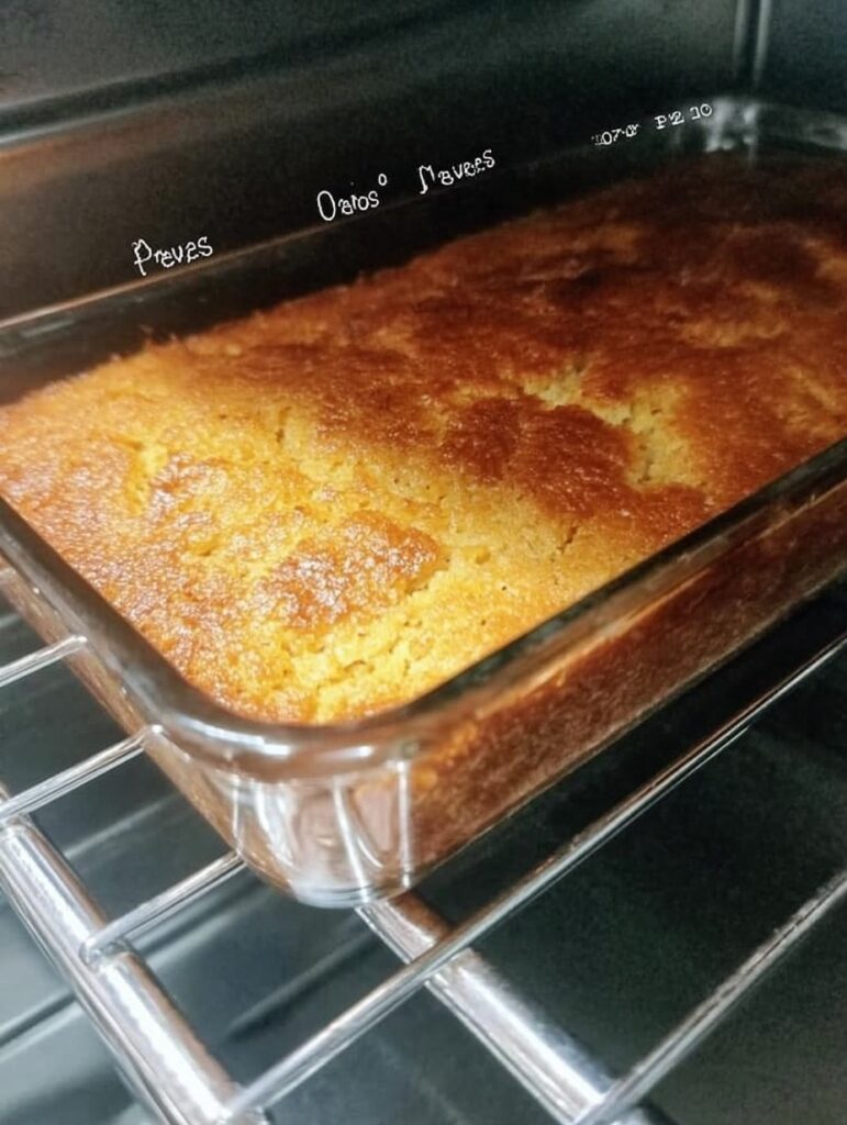Pan de elote casero sin harina, dorado por fuera, servido sobre una tabla de madera