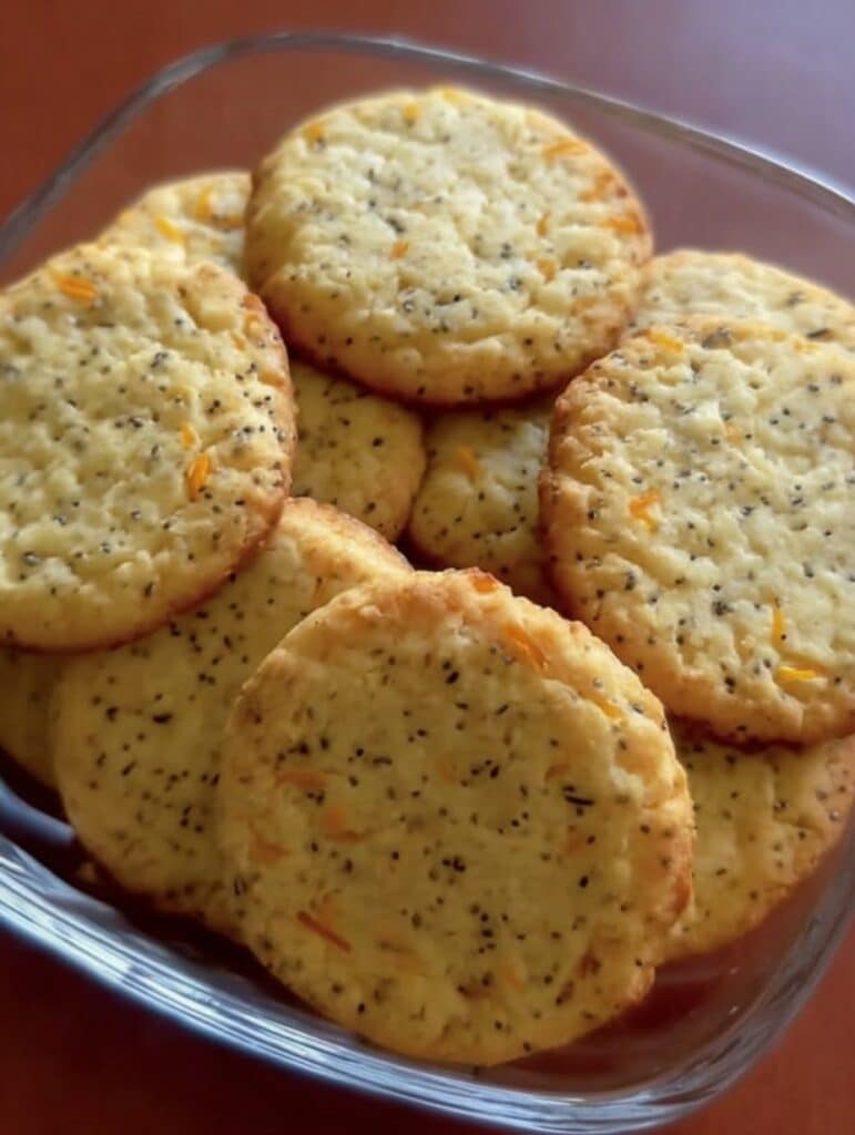 Primer plano de galletas caseras de naranja y chía, doradas y crujientes, recién horneadas.