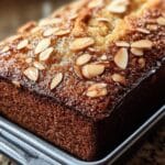 Pan dulce de almendras y yogur sin harina, recién horneado, con textura dorada y corteza crujiente.