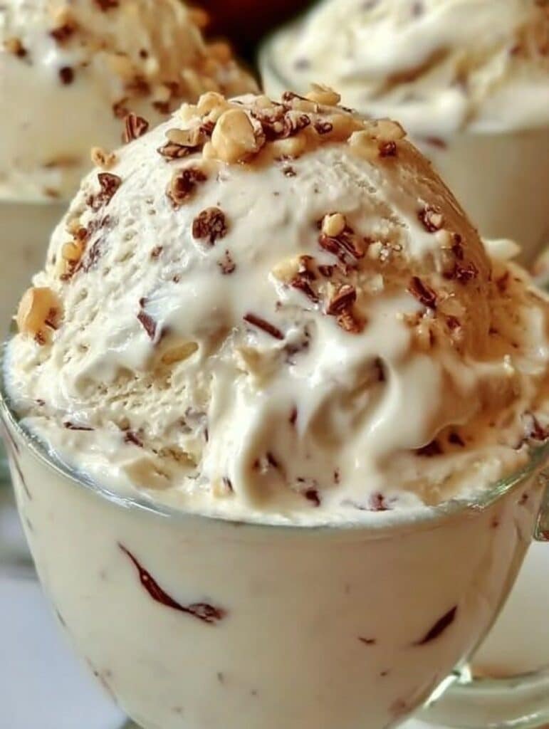 Helado casero de pedacitos con chispas de chocolate servido en una copa de vidrio.