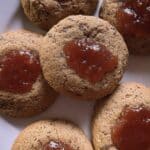 Galletas integrales caseras con dulce de membrillo recién horneadas sobre una mesa de madera