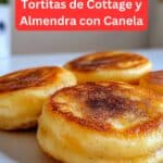 Mini tortitas de cottage y almendra con toque de canela recién horneadas, servidas en un plato blanco con frutas frescas y miel.