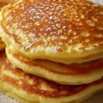 "Panqueques de requesón caseros servidos con frutas frescas y miel, un desayuno saludable y esponjoso."