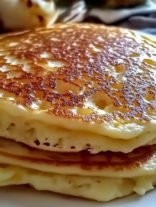 Pancakes saludables de queso cottage servidos con frutas frescas y miel, desayuno alto en proteínas y sin harinas refinadas.