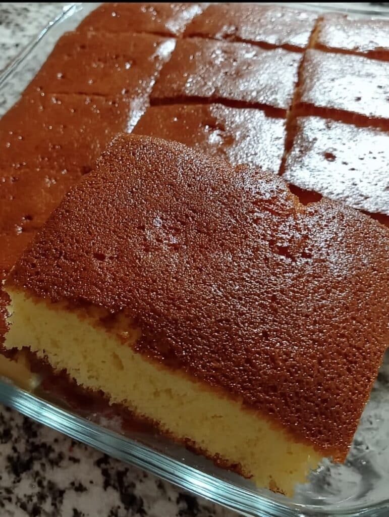 Bizcocho casero esponjoso recién horneado sobre una rejilla de cocina.