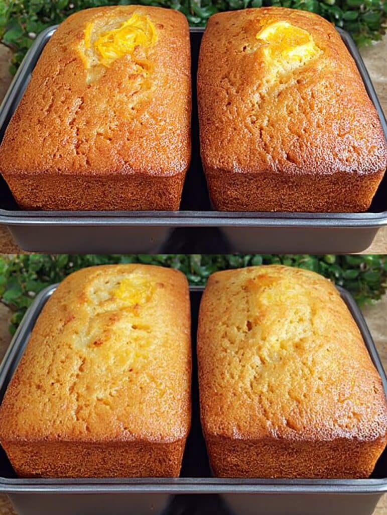 Pastel de naranja casero, esponjoso y dorado, recién salido del horno sobre una mesa de madera.