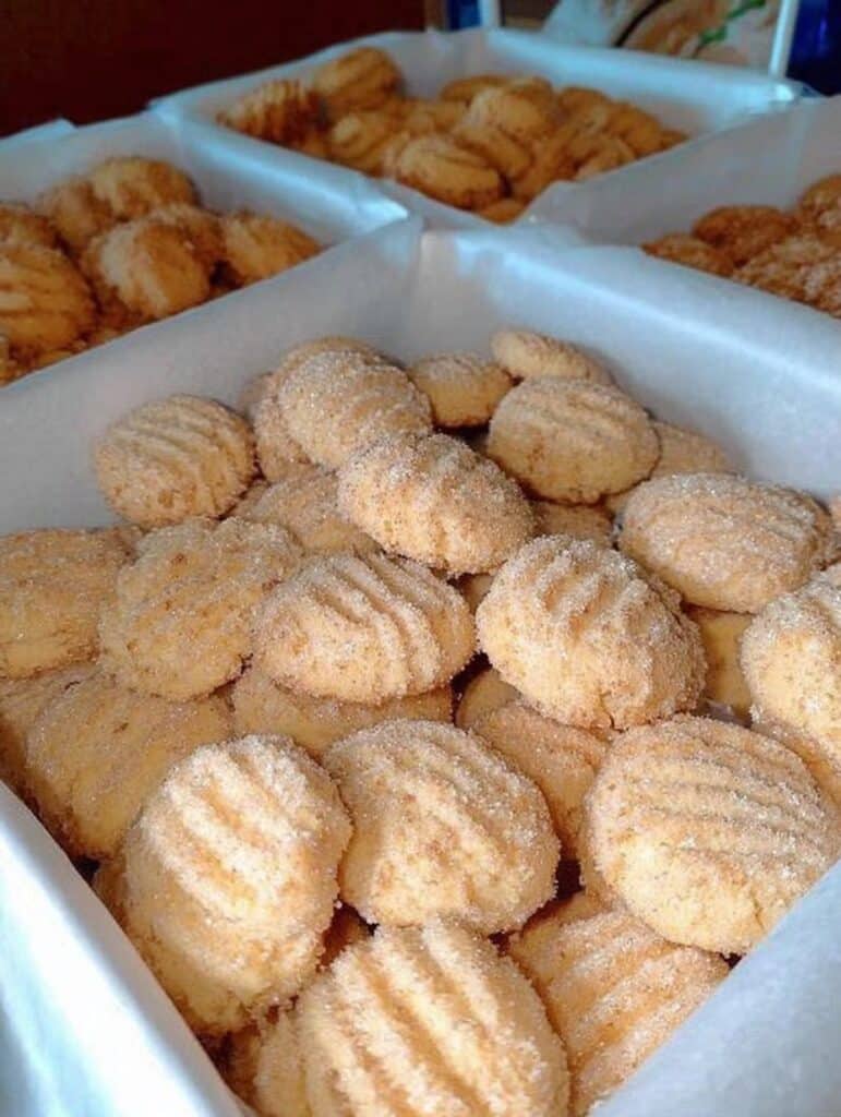 Galletas de queso crema caseras recién horneadas sobre una rejilla, doradas y suaves, listas para servir con café.