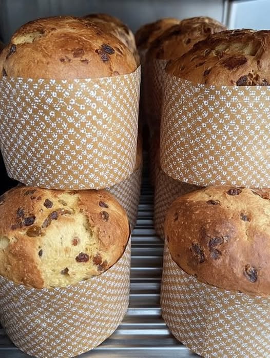 Pan dulce casero con frutos secos recién horneado sobre una mesa de madera.