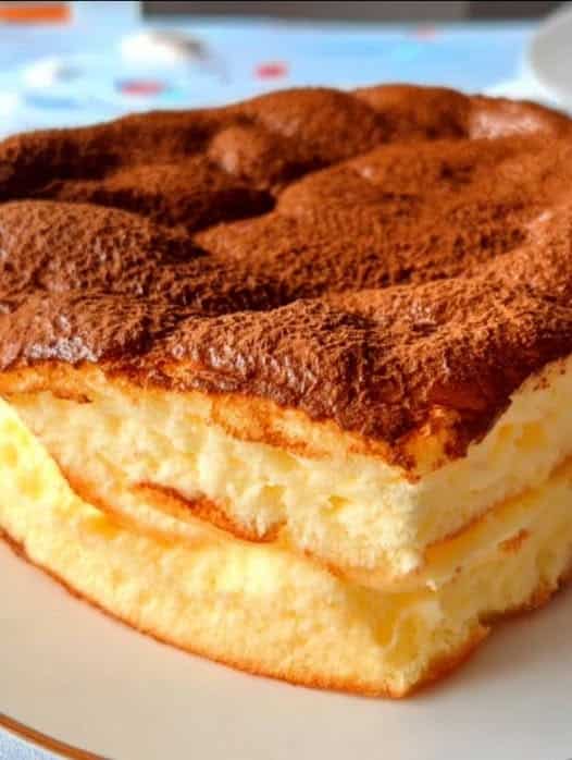 Tarta portuguesa de leche con tres capas: flan, crema y bizcocho, espolvoreada con canela.
